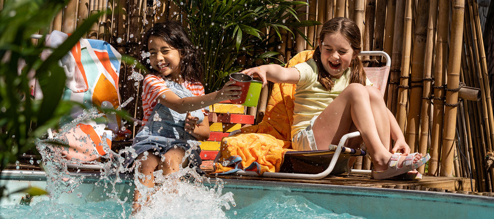 Kids with cups by swimming pool
