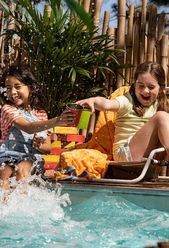 Kids with cups by swimming pool